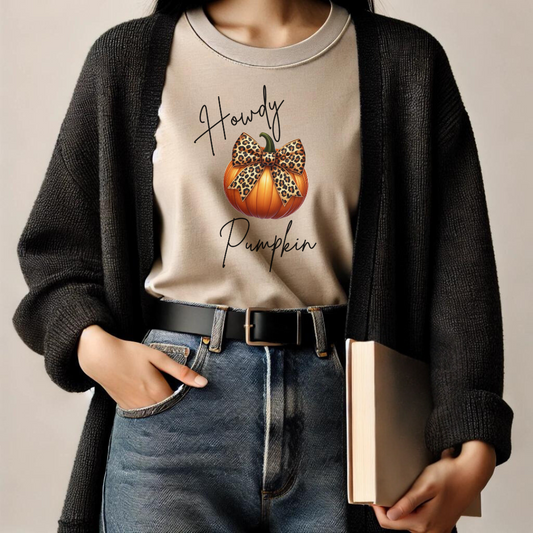 Add a touch of wild style to your fall wardrobe with our Howdy Pumpkin t-shirt! This unique design features a classic autumn pumpkin adorned with a bold leopard-print bow, perfectly blending the rustic charm of the season with a dash of fierce fashion. Whether you're heading to the pumpkin patch, enjoying a cozy fall day, or gearing up for Halloween festivities, this t-shirt is sure to turn heads.