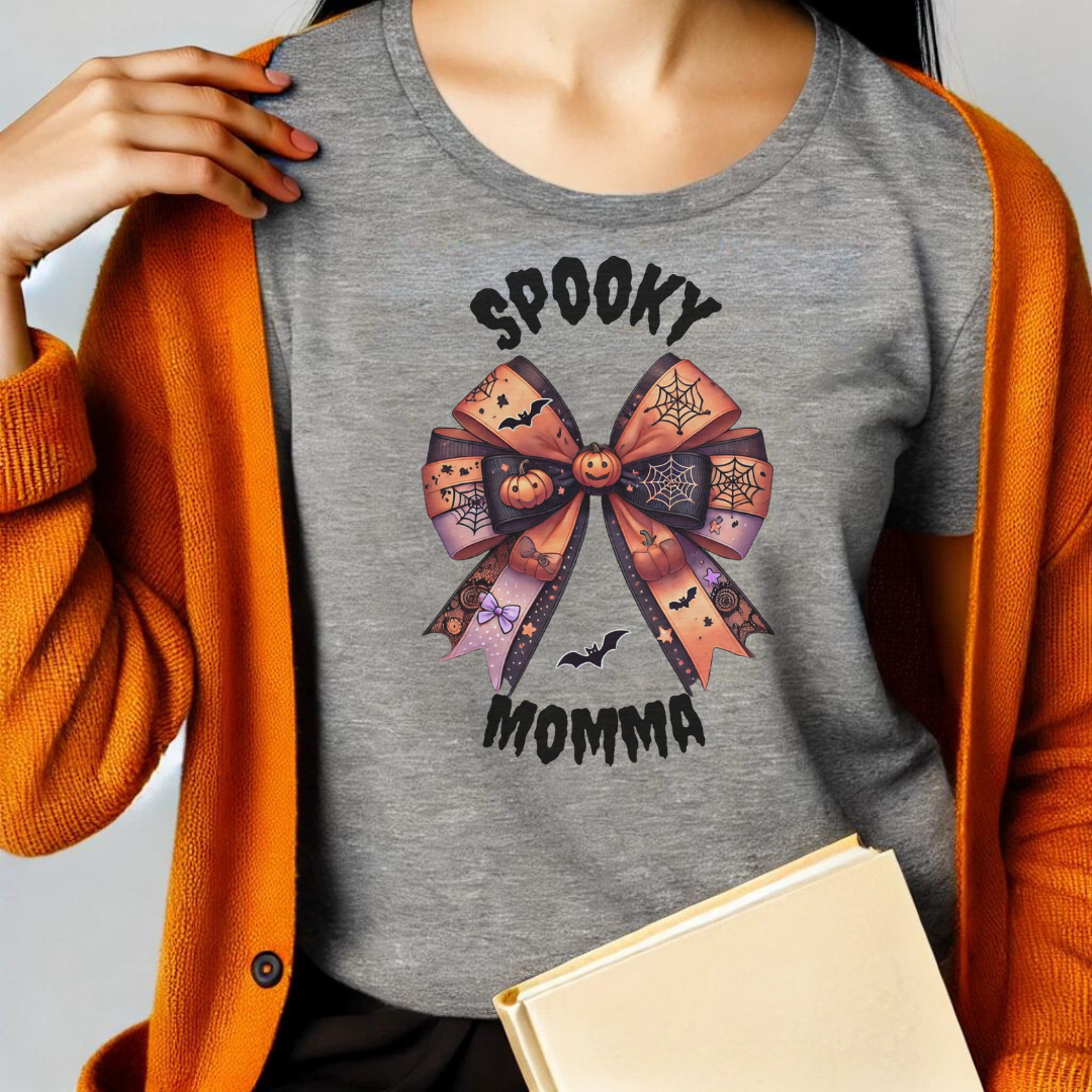 Embrace the spooky season in style with our Spooky Momma t-shirt! This unique design features a charming Halloween coquette bow adorned with pumpkins, bats, and spider webs, capturing the perfect blend of cute and creepy. The "Spooky Momma" text adds a fun, festive touch, making this shirt a must-have for any Halloween-loving mom.